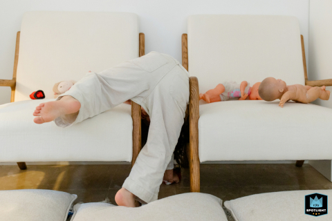 In Lisbon, Portugal, a young girl is captured in a documentary-style photo as she hides on an armchair, appearing to climb the piece of furniture.